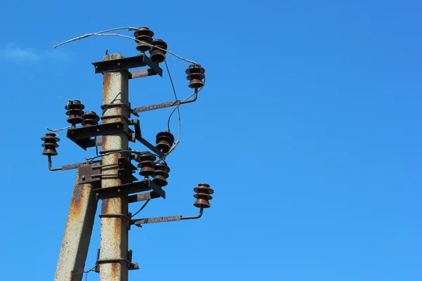 Gamla rostiga elektriska pole med isolatorer och trasiga ledningar igen — Stockfoto