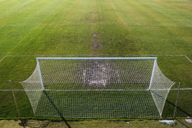 Boş futbol sahası ve gate yakınındaki çiğnenmiş çimen.