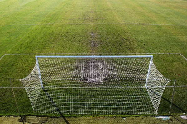Campo de futebol vazio e grama pisoteada perto do portão . — Fotografia de Stock