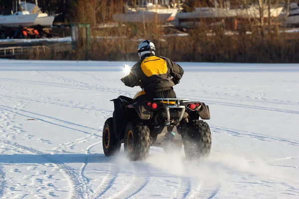 Quad moto motorista passeios sobre lago congelado — Fotografia de Stock