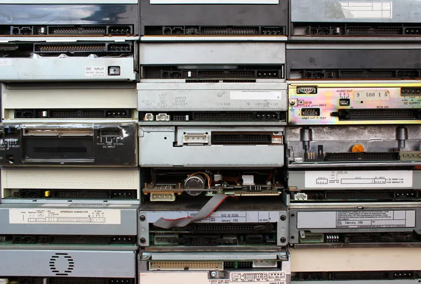 Rückwände alter Diskettenlaufwerke und DVDs als Hintergrund — Stockfoto