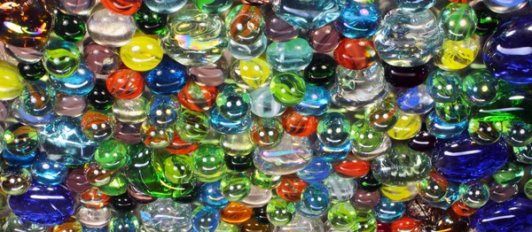 Mnoho barevné skleněné kuličky s smiley light reflexe — Stock fotografie