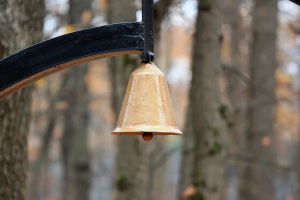 Stål målade bell hängande i en skog. — Stockfoto