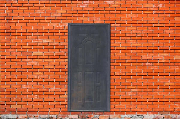 Закрытая металлическая дверь в центре стены из красного кирпича — стоковое фото