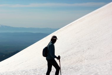 Kadın trekker kar dağ yamacında silüeti