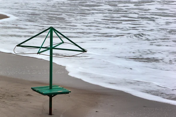 Ancien cadre métallique de parasol sur le bord de la mer. Vagues sur une plage de sable — Photo