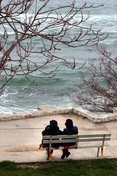 Coppia di donne sedute sulla panchina davanti al freddo inverno — Foto Stock