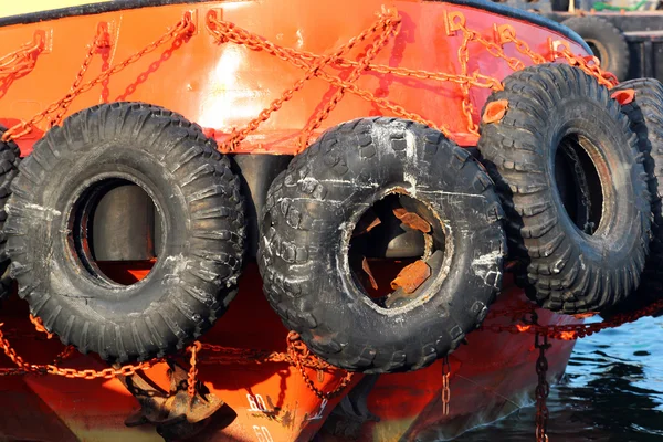 Neumáticos viejos usados como guardabarros en un barco — Foto de Stock