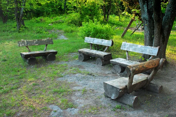 Viejos bancos de madera hechos a mano de troncos de árboles en el bosque — Foto de Stock