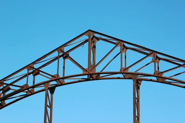 Dettaglio del vecchio ponte in metallo arrugginito sullo sfondo del cielo blu — Foto Stock