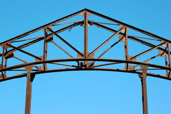 Dettaglio di vecchio ponte in metallo arrugginito su sfondo cielo blu — Foto Stock