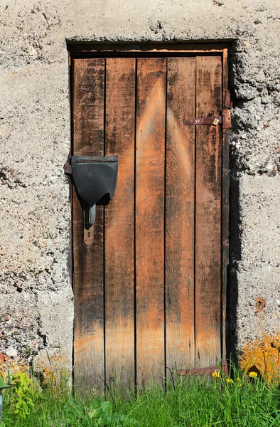 Vieille porte fermée en bois laiteux dans un mur de pierre — Photo