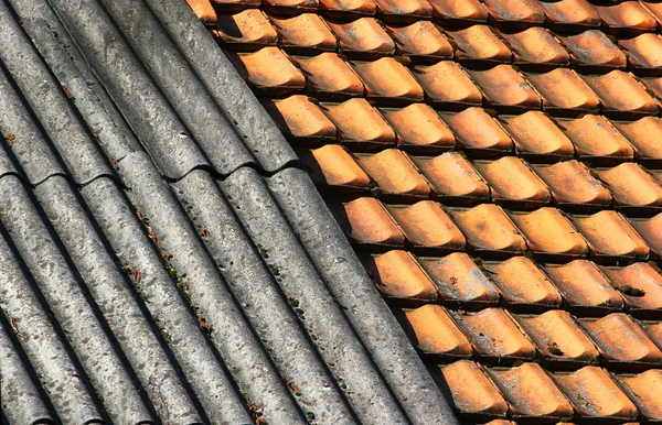 Old dirty weathered wavy slate and ceramic tiles shingle roof — Stock Photo, Image