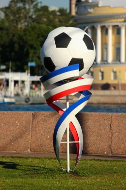 Saint Petersburg, Rusya - 4 Temmuz 2017: Neva nehir kıyısında futbol topu heykeli ve Rus bayrağı renkli kurdeleler.