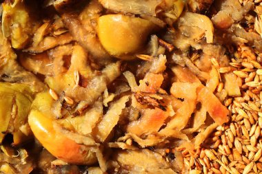 Kaynamış elma ve buğday, arka plan olarak bir tavuk ve kümes hayvanı yemi