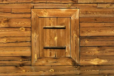 Ahşap bir duvarın kapalı penceresi. Doğal mimari arka plan.