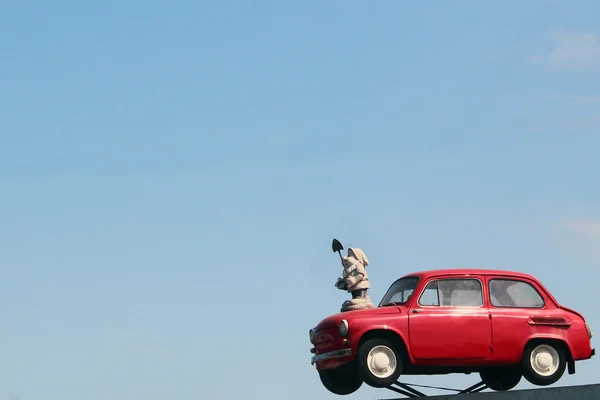 Παλαιό κόκκινο αυτοκίνητο στον γαλάζιο ουρανό φόντο οδική πινακίδα — Φωτογραφία Αρχείου