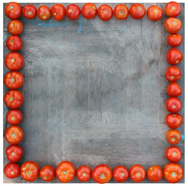 Tomates alineados alrededor del tablero cuadrado de madera como marco — Foto de Stock