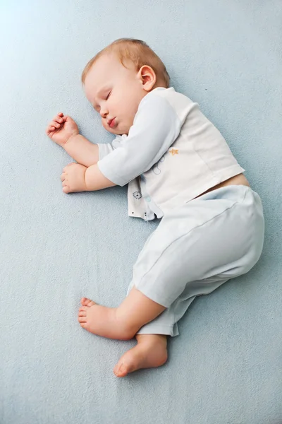 Bebê tranquilo deitado em uma cama enquanto dorme — Fotografia de Stock