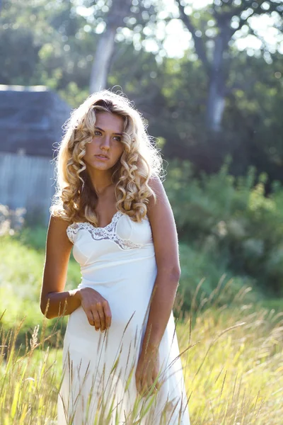 Hermosa chica en vestido blanco caminando en el prado en el día de verano —  Fotos de Stock