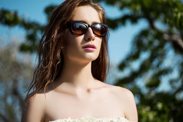 Primer plano retrato de mujer hermosa y de moda en gafas de sol, toma de estudio. Maquillaje profesional y peinado — Foto de Stock