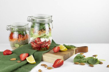Sağlıklı vejetaryen ev yapımı Mason Jar taze salatası ve yanında nohut, çilek ve sebze. Arka planda kesme tahtası. Diyet, Detoks, Temiz Yeme, Vegan çiğ gıda konsepti..
