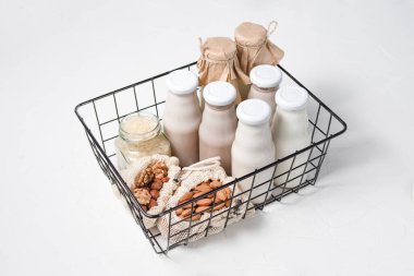 çeşitli cam şişelerdeki fındık ve tahıllardan laktozsuz süt çeşitleri. Fındık, yulaf, Hindistan cevizi, badem, ceviz...