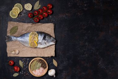 Çatal bıçaklı taze dorado balığı. Karanlık bir arka planda. Zeytinyağı, limon, kırmızı biber, sarımsak, tuz ve biberle pişirmek. Akdeniz diyetinin yemeği