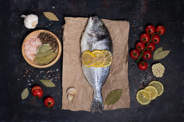 Çatal bıçaklı taze dorado balığı. Karanlık bir arka planda. Zeytinyağı, limon, kırmızı biber, sarımsak, tuz ve biberle pişirmek. Akdeniz diyetinin yemeği