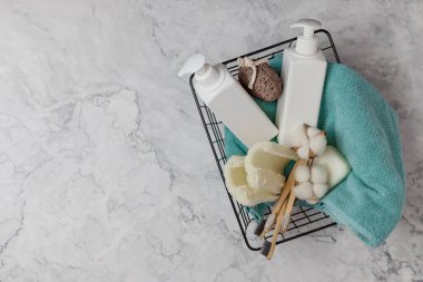 Duş aksesuarları sepetin içinde mermer bir arka planda. İçinde kozmetik, lif, diş fırçası ve havlu şişeleri var. DIY Eko Kozmetik. Kavram sıfır atık, sürdürülebilir. kopyalama alanı. düz yat
