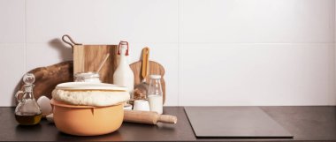 Hamur mayası, ekmek pişirmek için diğer malzemelerin yanında masada duruyor..