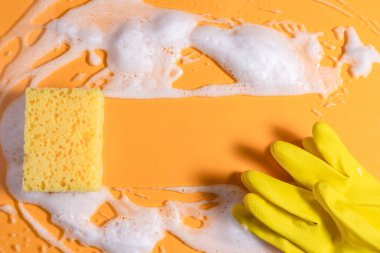 Sabunla temizlik süngeri. Sarı arka planda köpük köpüklü doku. kopyalama alanı. Süngerle temizlik..