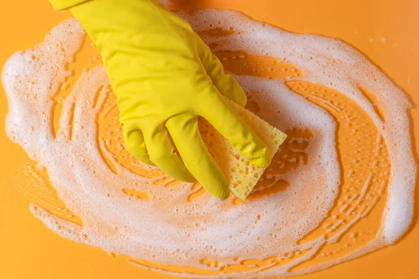 Cleaning sponge with soap. Texture with bubble suds on yellow background. copy space. Housekeeping cleaning with sponge.