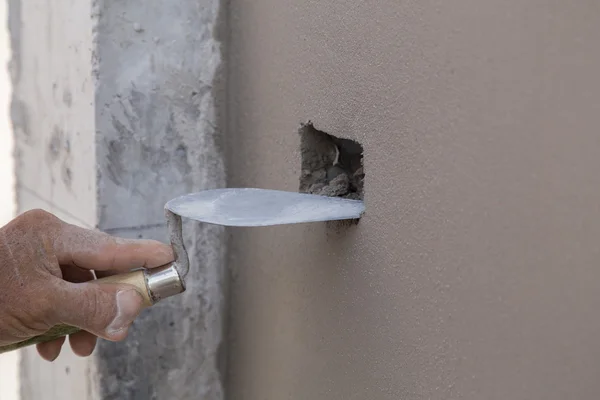 Mano utilizando paleta para terminar pared de hormigón húmedo en la construcción si — Foto de Stock