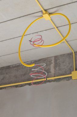 Elektrik kutuları ve kabloları concre üzerinde gömülü sarı Pvc boru