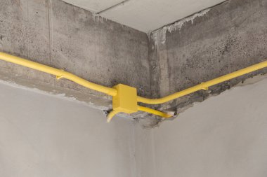 Elektrik kutuları ve kabloları concre üzerinde gömülü sarı Pvc boru