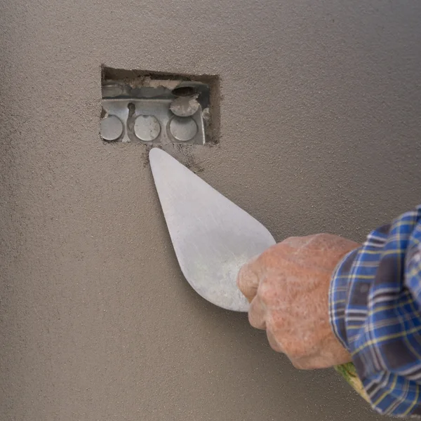 Main à l'aide de truelle pour finir mur de béton humide à la construction si — Photo