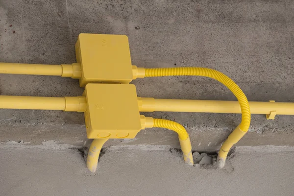 Yellow PVC pipes for electrical boxes and wires buried on concre — Stock Photo, Image