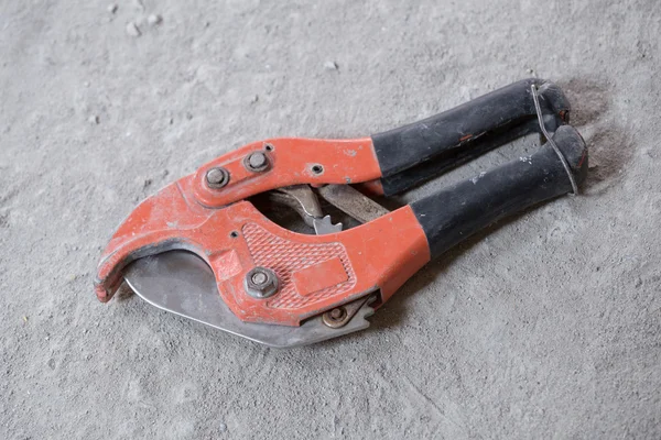 Red scissors for cutting plastic pipe — Stock Photo, Image