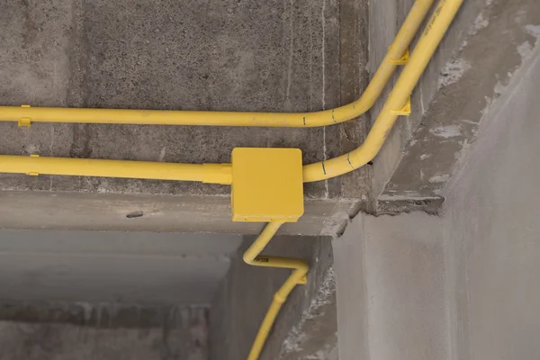 Yellow PVC pipes for electrical boxes and wires buried on concre — Stock Photo, Image