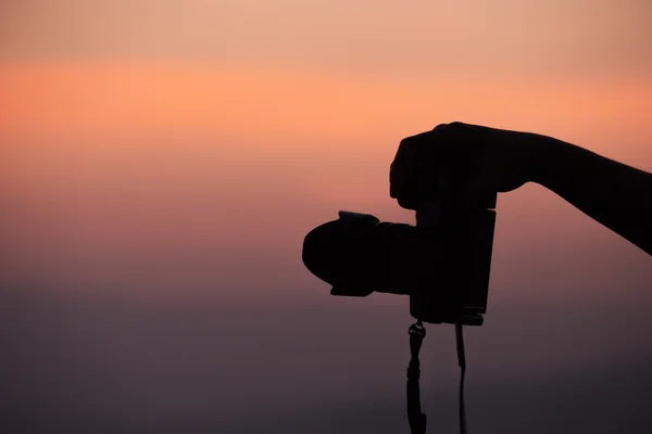 Σιλουέτα του χέρι γυρίσματα με κάμερα στο ηλιοβασίλεμα — Φωτογραφία Αρχείου