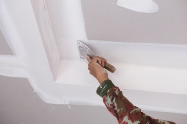 hand of worker using gypsum plaster ceiling joints clipart
