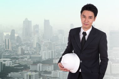 Şehir arka plan beyaz kask tutan mühendisi