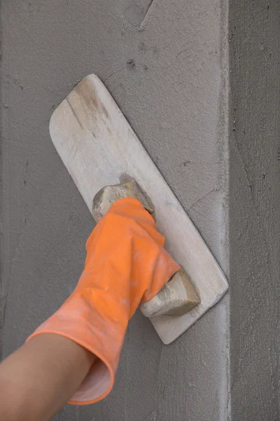 Mano del lavoratore uso spatola intonaco calcestruzzo a parete — Foto Stock