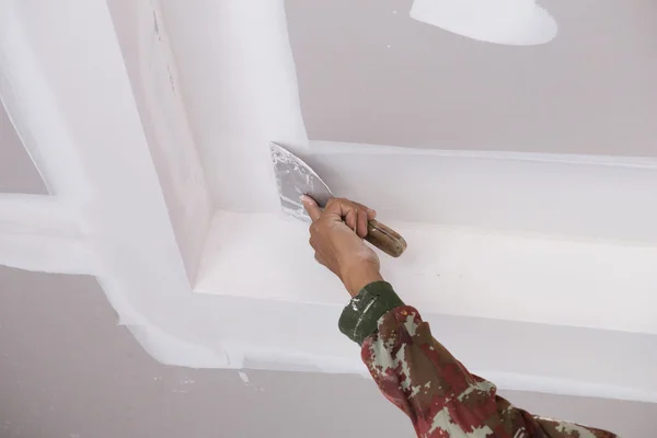 Рука работника с помощью гипсокартона потолочных соединений — стоковое фото