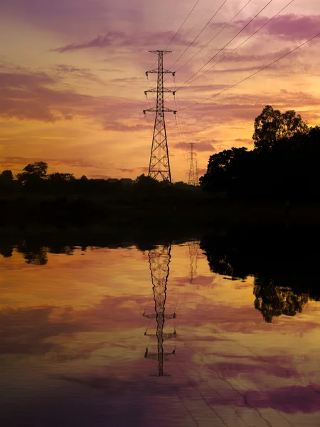 Silhouette de poteau haute tension avec réflexion de l'eau — Photo