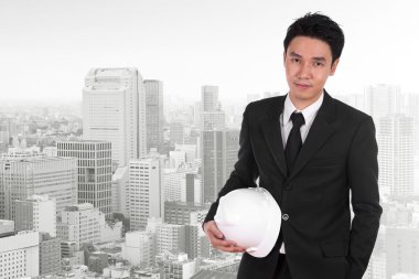 Şehir arka plan beyaz kask tutan mühendisi