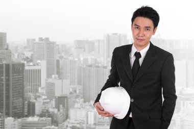 Şehir arka plan beyaz kask tutan mühendisi