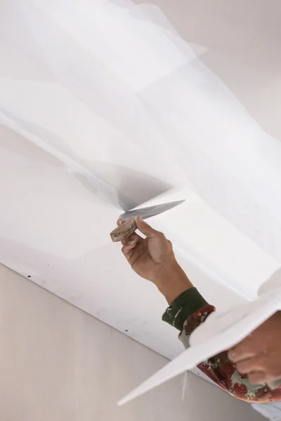 石膏プラスター天井継手を用いた労働者の手 — ストック写真
