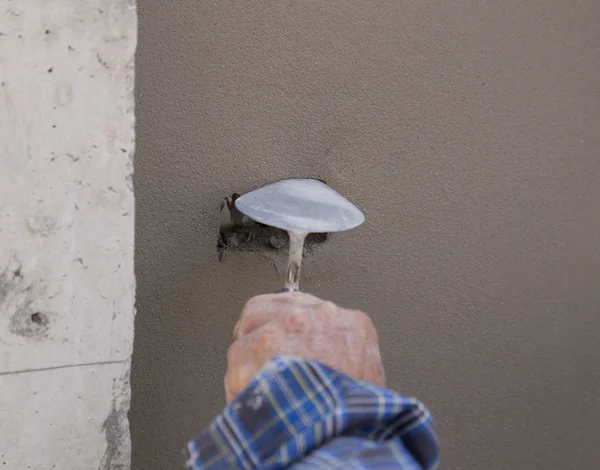 Hand using trowel to finish wet concrete wall at construction si — Stock Photo, Image